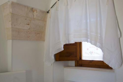- une fenêtre avec un rideau blanc dans la salle de bains dans l'établissement Casa Nonna Renzina, à Locorotondo