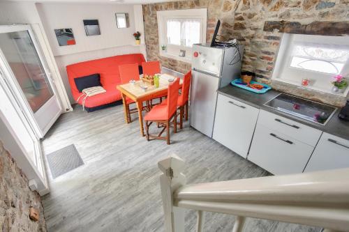 une petite cuisine et salle à manger avec une table et des chaises dans l'établissement Escale à deux pas de la plage du Val André, à Pléneuf-Val-André