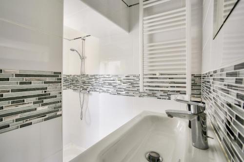 une salle de bain blanche avec un lavabo et une douche dans l'établissement Escale à deux pas de la plage du Val André, à Pléneuf-Val-André