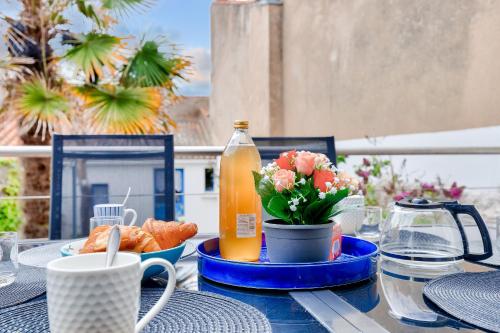 - une table avec une assiette de nourriture et une bouteille de jus d'orange dans l'établissement 400m de la plage - maison avec jardin, à Les Sables-dʼOlonne