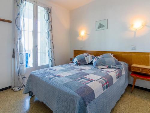 - une chambre avec un lit doté d'une couverture bleue et d'une fenêtre dans l'établissement Apartamento Llançà, 2 dormitorios, 4 personas - ES-228-24, à Llançà