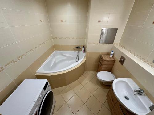 a bathroom with a tub and a toilet and a sink at IOS Garden in Prague