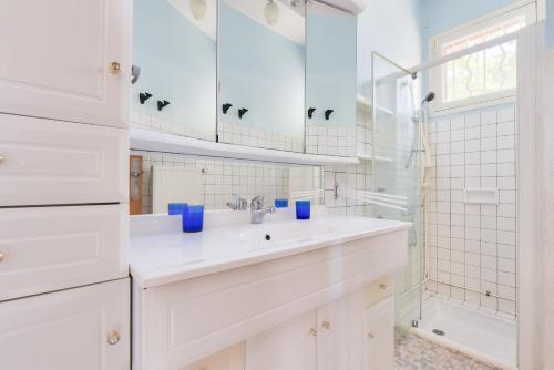 une salle de bain blanche avec un lavabo et une douche dans l'établissement Maison pour 8 - 300m plage du Mauret, à Andernos-les-Bains