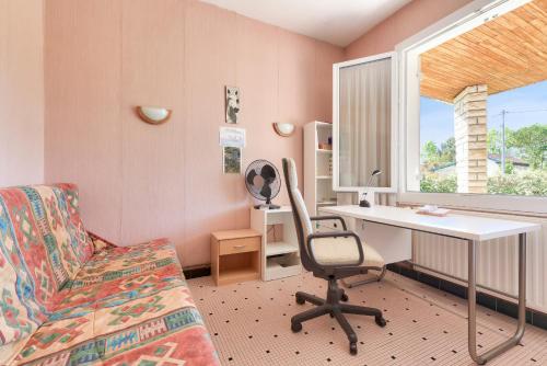 Cette chambre comprend un bureau, une chaise et un lit. dans l'établissement Maison pour 8 - 300m plage du Mauret, à Andernos-les-Bains