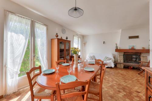 une salle à manger avec une table et des chaises et une cheminée dans l'établissement Vacances en famille - Jardin - 800m de la plage, à Saint-Gildas-de-Rhuys