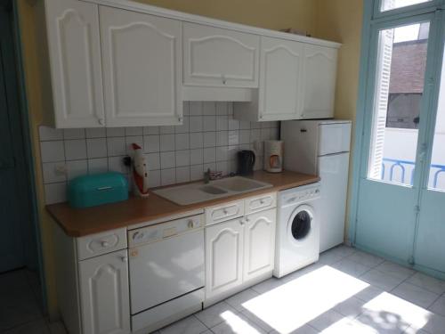 une cuisine avec des armoires blanches et une machine à laver dans l'établissement Villa La Cressonnière, à Trouville-sur-Mer