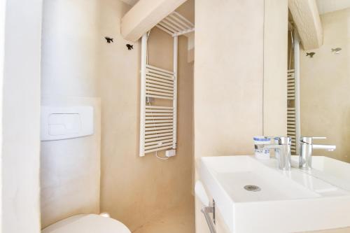 ein weißes Bad mit einem WC und einem Waschbecken in der Unterkunft Escapade familiale a deux pas de la plage in La Guérinière