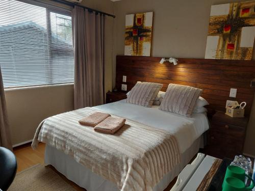 1 dormitorio con 1 cama con 2 toallas en Villa Mariss Guesthouse en Kraaifontein