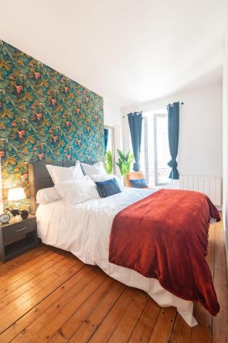 une chambre avec un grand lit avec un tableau au mur dans l'établissement Appartement 2 pièces Paris, à Gentilly