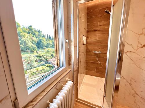 a bathroom with a window and a shower with a radiator at Attici Alba e Tramonto in Brescia