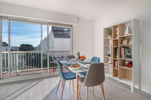 une salle à manger avec une table et des chaises et une grande fenêtre dans l'établissement Le Pouliguen - 100 du port - Escale à deux, au Pouliguen