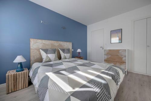 een slaapkamer met een groot bed met blauwe muren bij Séjour en duo tout près du port au Pouliguen in Le Pouliguen