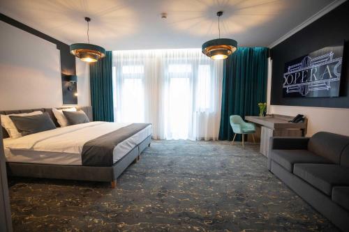 una camera con letto, divano e scrivania di Opera Hotel a Timişoara