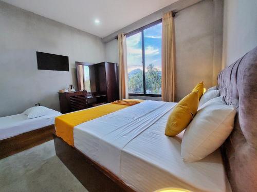 a bedroom with two beds and a large window at Catch Up Dambulla in Dambulla