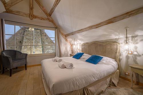 ein Schlafzimmer mit einem Bett mit blauen Kissen und einem Fenster in der Unterkunft Charmante longere pour un doux sejour in Pluvigner