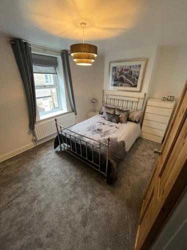 a bedroom with a bed and a large window at Wolf Hollow, sleeps 4 adults plus 2 children, Buxton town centre in Buxton