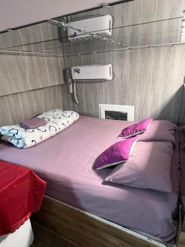 a bed in a tent with purple sheets and pillows at Good choise in Chişinău