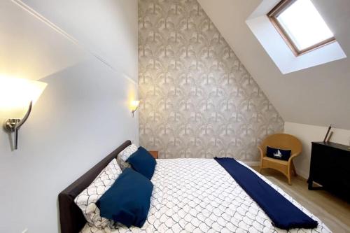 - une chambre avec un lit et des oreillers bleus dans l'établissement Magnifique appartement plein sud - Piscine, au Croisic