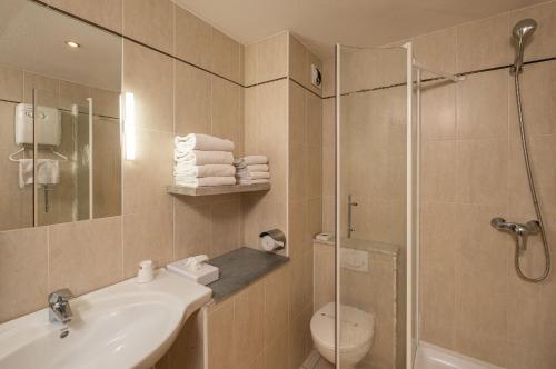 La salle de bains est pourvue d'une douche, d'un lavabo et de toilettes. dans l'établissement The Originals City, Hôtel L'Hippocampe, Sète Balaruc-le-Vieux, à Balaruc-le-Vieux