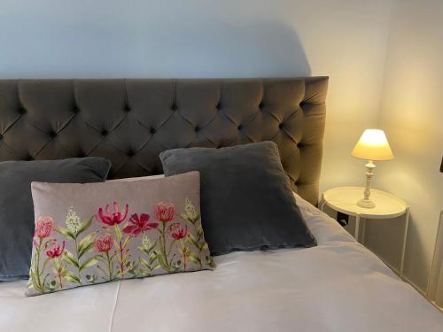 a bed with a headboard and two pillows at B&B Aline Florentine in Kortenberg