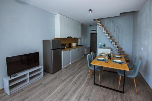 a kitchen and dining room with a table and a television at AthmosphereVillaEma Apartments in Kranevo