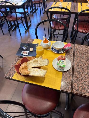 een tafel met een bord eten en brood erop bij Hotel De La Place in Malakoff