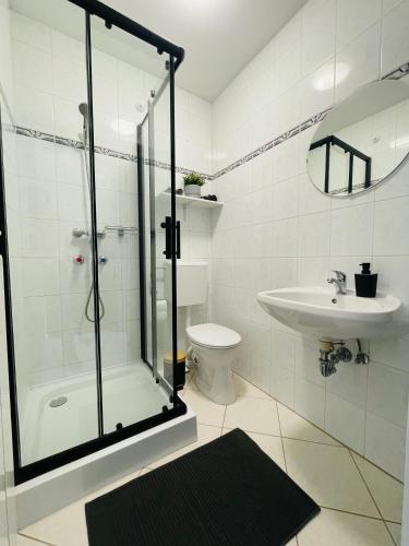 a bathroom with a shower and a toilet and a sink at Hencz Vendégház in Balatonakarattya