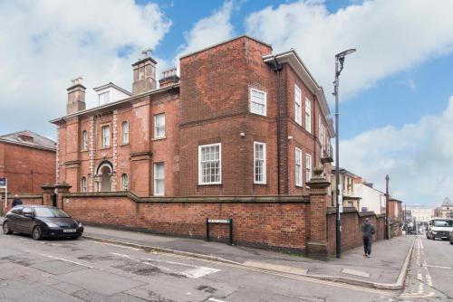 a red brick building on a street with a car parked in front at cheerful double en-suite with free wifi in Derby