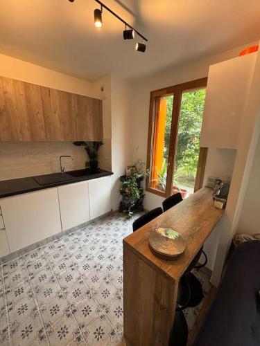 une cuisine avec un comptoir en bois dans une pièce dans l'établissement JO : Charmant appart proche de Paris, à LʼÎle-Saint-Denis