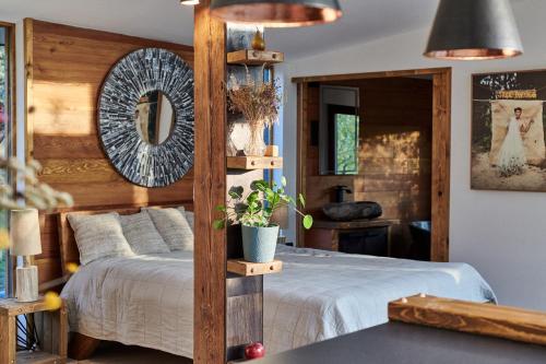 a bedroom with a bed and a mirror at Életem Vendégház in Esztergom