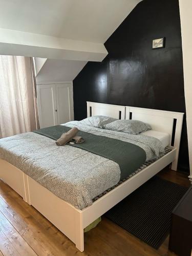 a bed with a pair of shoes sitting on it at Cozy Loft - Proche Gare - Nemours in Nemours