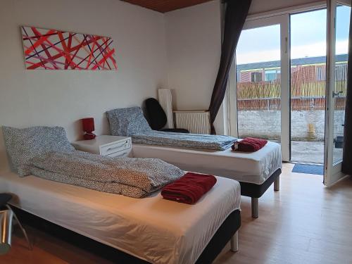 a bedroom with three beds and a window with a view at Room near Copenhagen in Ishøj