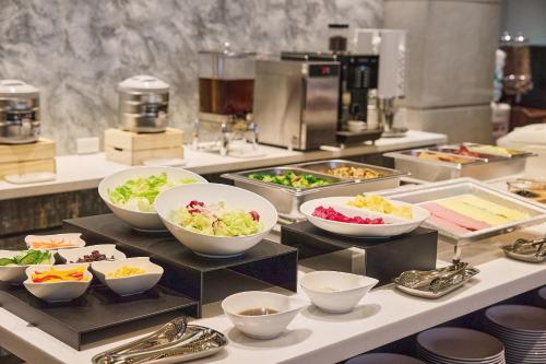 a buffet with bowls of food on a counter at Orange Hotel - Linsen, Taipei in Taipei