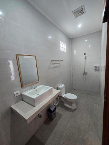 a bathroom with a sink and a toilet and a mirror at The Lucky Canggu 2 in Canggu