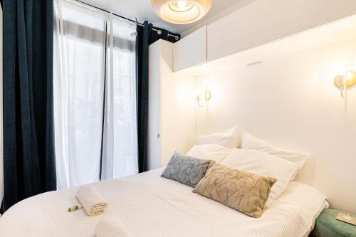 une chambre avec un lit blanc avec une fenêtre dans l'établissement GuestReady - 2BR Apt Paris Expo Porte Versailles, à Paris