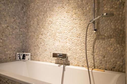 a shower in a bathroom with a white tub at Boutique appartment with vue on sea and dunes in Koksijde