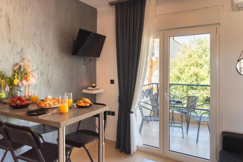 a living room with a table and a balcony at Valeria Apartament Cozy & Quiet in Kallithea Halkidikis