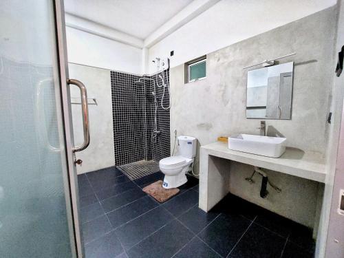 a bathroom with a shower and a toilet and a sink at Catch Up Dambulla in Dambulla