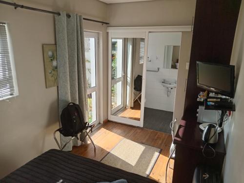 a bedroom with a bed and a door to a bathroom at Urban Manor in Port Elizabeth