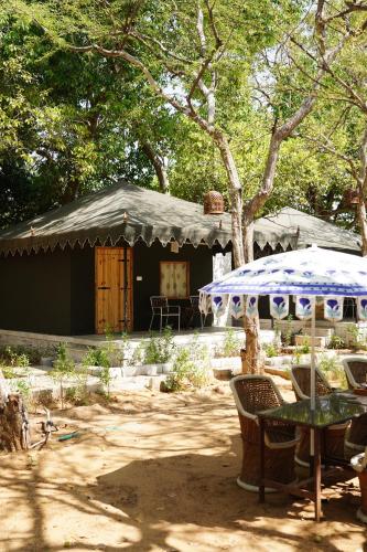 a tent with a table and chairs in a yard at Heli Pushkar in Pushkar