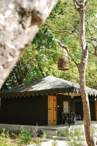 a black tent with a table and chairs in front of it at Heli Pushkar in Pushkar