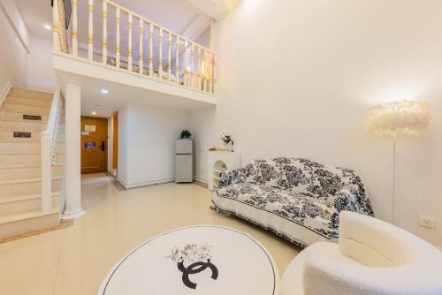 a living room with a bed and a table at Lavendar Duplex Apartment in Guangzhou