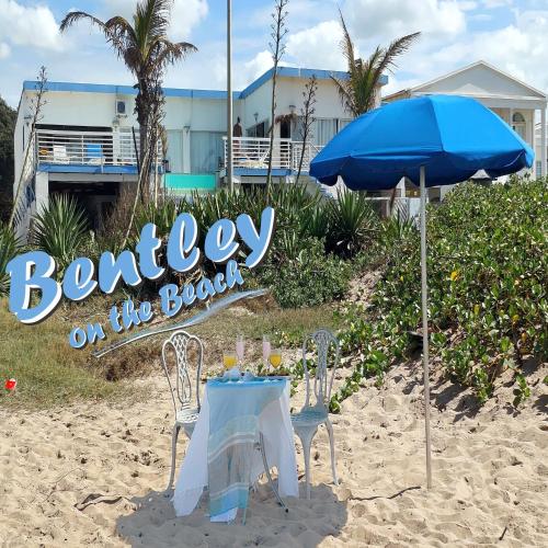 a table and an umbrella on the beach at Bentley on the Beach in Umhlanga