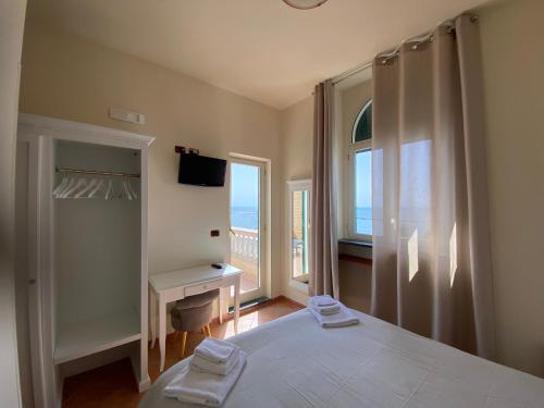 sypialnia z łóżkiem i widokiem na ocean w obiekcie Villino Gregoraci Relais w mieście Santa Marinella
