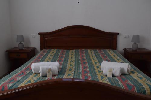 a bedroom with a bed with two towels on it at La Masseria Hotel Ristorante Centro Benessere in Cocumola