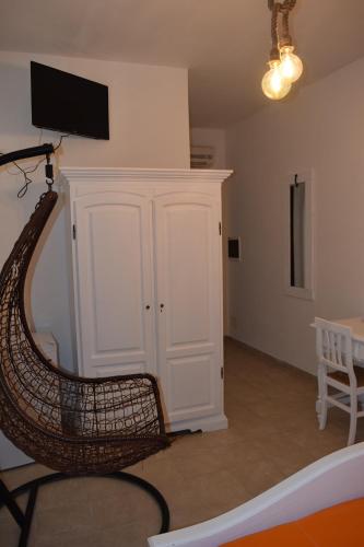 a room with a wicker chair and a tv on a wall at La Masseria Hotel Ristorante Centro Benessere in Cocumola