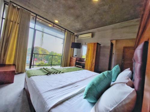 a bedroom with a large bed with a large window at Catch Up Dambulla in Dambulla