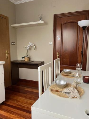 uma cozinha com uma mesa branca com 2 cadeiras e uma sala de jantar em APARTAMENTO NIK en casa chalet con parking y jardin em Erandio