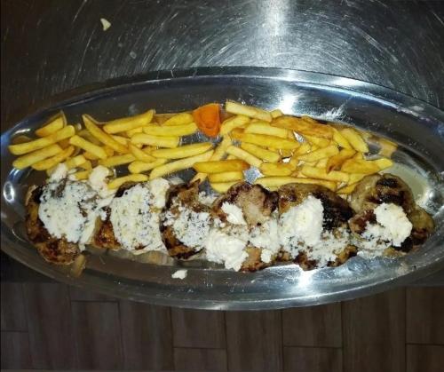a plate of food with french fries and meat at Kod Goluba na Tari in Šljivovica
