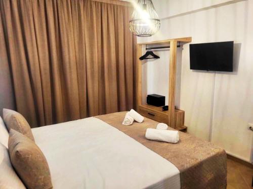 Kasapakis Hotel & Apartments في خيرسونيسوس: غرفه فندقيه سرير وتلفزيون